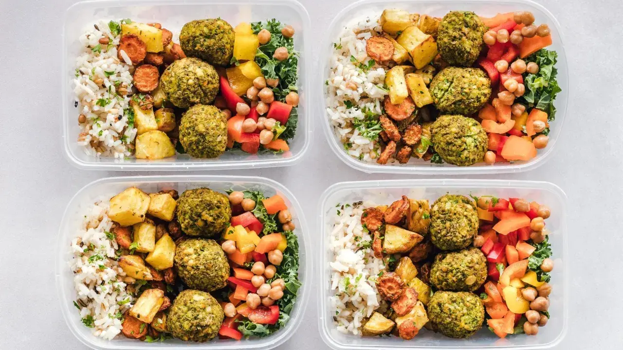 Vier Behälter mit leckeren meal prep Rezepten: Reis, gebratenes Gemüse, Falafel und bunte Paprika.