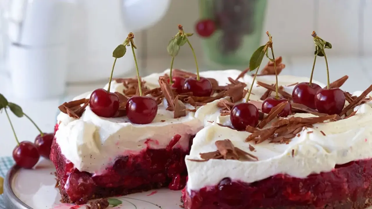 Ein saftiger Kirsch Sahne Kuchen mit frischen Kirschen und Schokostreuseln, bereit zum Genießen.