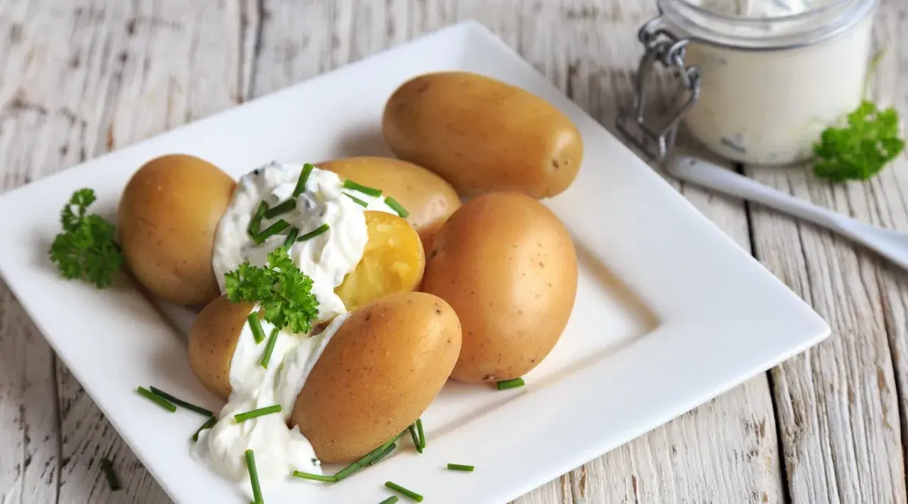Kleine, goldbraune Kartoffeln mit cremigem Quark und frischem Schnittlauch garniert. Ein Klassiker: Kartoffeln mit Quark.