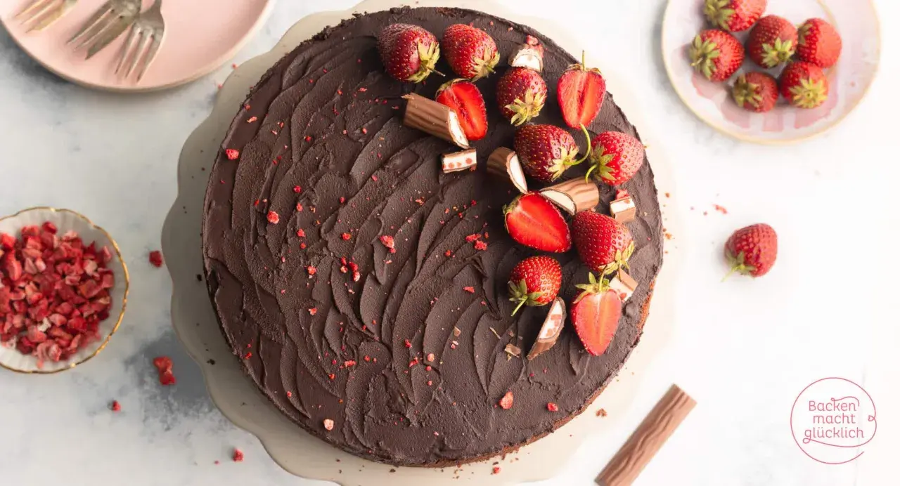 Schokoladige Yogurette Torte mit frischen Erdbeeren und Schokoriegel-Stücken verziert. Ein Traum für jeden Kuchenliebhaber!