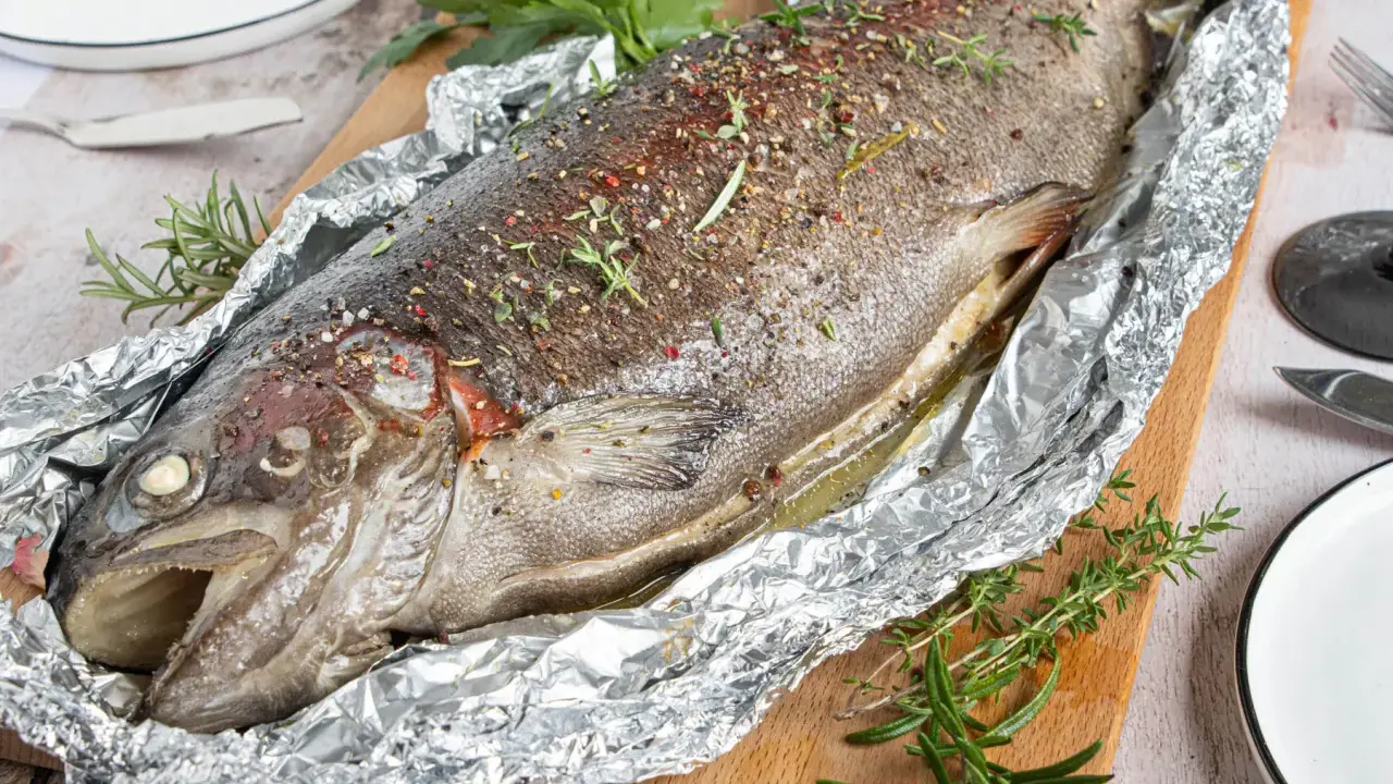 Saftige Lachsforelle im Backofen, mit Kräutern und Gewürzen verfeinert, bereit zum Servieren.