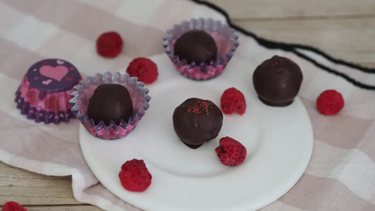 Schoko energy balls mit Himbeeren und Herz-förmigen Pralinenförmchen.