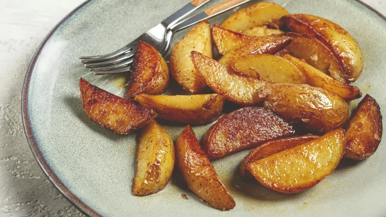 Goldbraune, knusprige Ofenkartoffeln auf einem Teller, bereit zum Genießen. Ein einfaches, leckeres Ofenkartoffeln Rezept.
