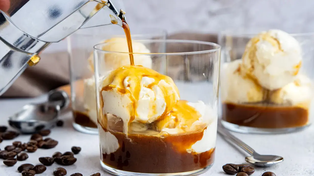 Heißer Kaffee fließt in ein Glas mit cremigem Vanilleeis. Ein köstlicher Affogato, perfekt für eine süße Erfrischung.