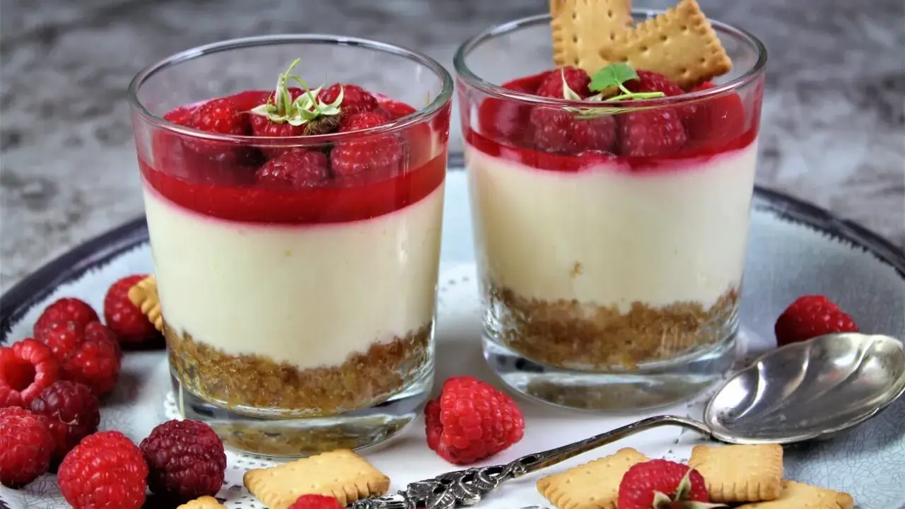 Zwei leckere Desserts im Glas mit Himbeeren und Keksen, ein Genuss für Augen und Gaumen.
