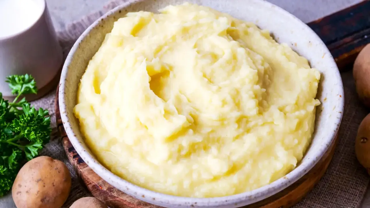 Cremiger Kartoffelbrei, perfekt für jedes Kartoffelbrei Rezept. Mit frischer Petersilie und Milch daneben.