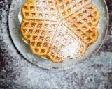 Herzförmige Waffeln, bestäubt mit Puderzucker, sehen aus wie aus einem perfekten Waffeln Rezept.