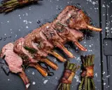 Ein perfekt gegrilltes Lammkarree mit Rosmarin und Speckbohnen. Das ganze Lamm grillen ist eine Kunst, die hier meisterhaft präsentiert wird.