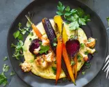 Bunte Wurzelgemüse und Blumenkohl auf cremiger Polenta – eine köstliche Idee, was passt zu Polenta vegetarisch.