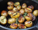 Gegrillte Rosmarinkartoffeln mit grobem Salz und Kräutern auf einem Rost. Perfekt für den Sommer!