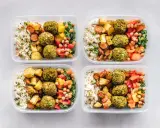 Vier Behälter mit leckeren meal prep Rezepten: Reis, gebratenes Gemüse, Falafel und bunte Paprika.