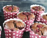 Saftige schokomuffins mit Himbeeren, gebacken in rot-weißen Pünktchen-Förmchen, warten auf ihren Genuss.