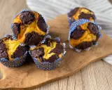 Zupfkuchen Muffins mit Schoko-Marmorierung in blauen Papierförmchen auf einem Holzbrett.