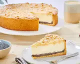 Ein köstlicher Mohn Schmand Kuchen mit Streuseln und Puderzucker. Daneben eine Schale Mohn und eine Tasse Kaffee.