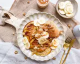 Bananen Pancakes ohne Ei, garniert mit Bananenscheiben, Nüssen und einer cremigen Sauce. Ein köstlicher Brunch-Traum!
