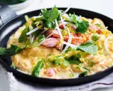 Leichte Sommergerichte: Ein Omelett mit Lachs, Sojasprossen, Koriander und Minze in einer Pfanne.
