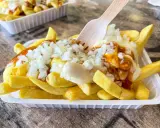 Pommes Spezial: goldgelbe Pommes mit Mayonnaise, Zwiebeln und einer würzigen Sauce, bereit zum Genuss.