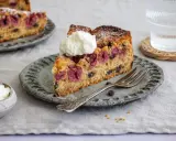Ein Stück saftiger nusskuchen mit pudding, Kirschen und Schokostückchen, garniert mit Sahne.