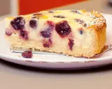 Ein Stück Kirsch-Schmand-Kuchen, wie ihn Landfrauen backen, mit saftigen Kirschen und Puderzucker bestäubt.
