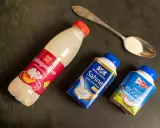 Schlagsahne zum Kochen: verschiedene Sahne-Produkte liegen neben einem Löffel mit Sahne.