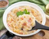 Herzhaftes Sauerkraut nach Hausfrauenart mit Speck und Kümmel, garniert mit Petersilie. Ein Löffel voller Tradition.