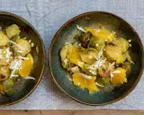Zwei Schalen mit Rosenkohl, Orangenstücken und geriebenem Käse. Ein Gericht, das an ewiger Kohl Rezepte erinnert.