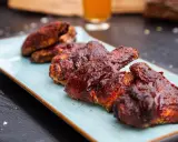 Saftige chicken wings in einer würzigen Marinade, serviert auf einem hellblauen Teller.
