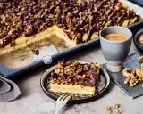 Ein Stück "friss dich dumm Kuchen" mit Schokoladen-Nuss-Decke und einer Tasse Kaffee.