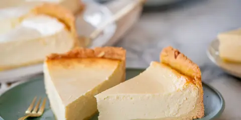 Zwei cremige Käsekuchenstücke auf einem grünen Teller, bereit zum Genießen. Perfekt für Ihre nächsten Kuchen Rezepte.