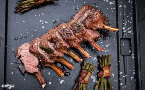Ein perfekt gegrilltes Lammkarree mit Rosmarin und Speckbohnen. Das ganze Lamm grillen ist eine Kunst, die hier meisterhaft präsentiert wird.