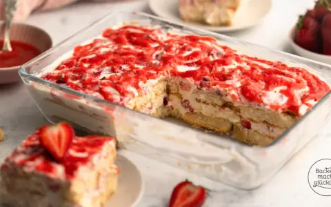 Ein saftiges Erdbeer Tiramisu in einer Glasform, geschichtet mit Löffelbiskuits, Creme und frischen Erdbeeren, verlockt zum Genuss.