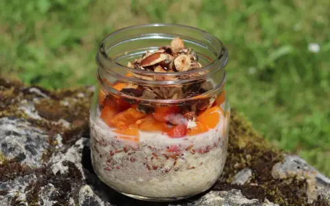 Veganes Overnight Oats im Glas mit Früchten und Nüssen, perfekt für einen gesunden Start in den Tag.