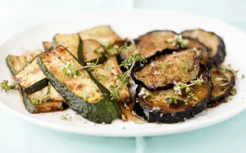 Gebratene Zucchini und Auberginen, italienisch gewürzt mit Kräutern, auf einem Teller.