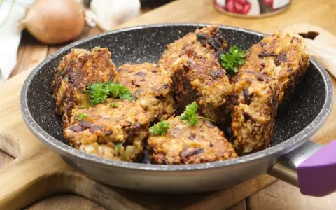 Herzhafte vegetarische Frikadellen mit Kidneybohnen und Kräutern in einer Pfanne, garniert mit Petersilie.