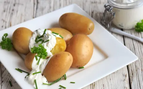 Kleine, goldbraune Kartoffeln mit cremigem Quark und frischem Schnittlauch garniert. Ein Klassiker: Kartoffeln mit Quark.