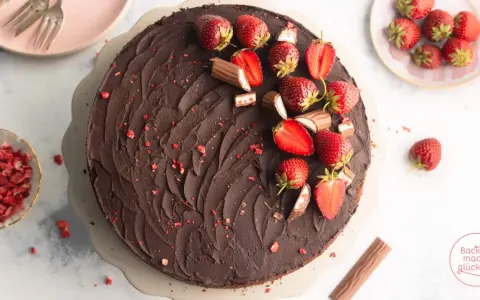 Schokoladige Yogurette Torte mit frischen Erdbeeren und Schokoriegel-Stücken verziert. Ein Traum für jeden Kuchenliebhaber!