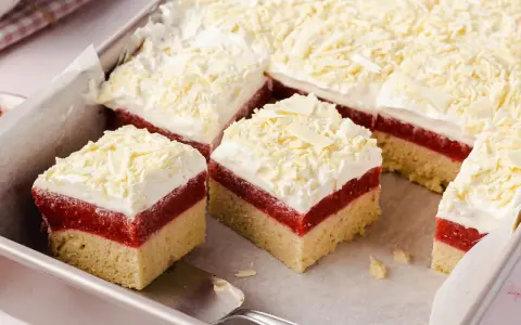 Schneeweiße Sahne und rote Fruchtschicht auf hellem Boden – dieser Frau Holle Kuchen sieht aus wie frisch aus dem Märchen!