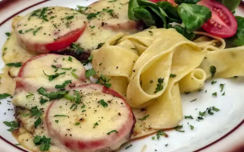 Schweinemedaillons mit Tomaten und Käse überbacken, dazu breite Bandnudeln und ein kleiner Salat. Perfekt für schnelle schweine minutensteaks im backofen.