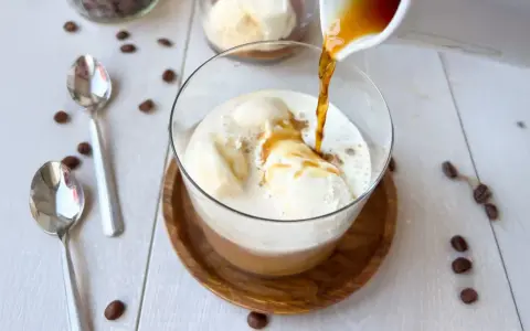 Ein heißer Espresso fließt über cremiges Vanilleeis. Ein perfekter Affogato Cafe, bereit zum Genießen.