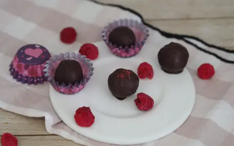 Schoko energy balls mit Himbeeren und Herz-förmigen Pralinenförmchen.