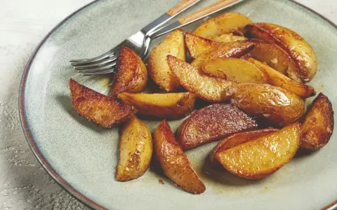 Goldbraune, knusprige Ofenkartoffeln auf einem Teller, bereit zum Genießen. Ein einfaches, leckeres Ofenkartoffeln Rezept.