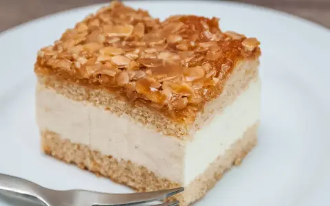 Ein Stück Kuchen mit cremiger Füllung und karamellisierten Mandeln. Der Kuchen wird zu dunkel, aber die Mandeln sind perfekt gebräunt.