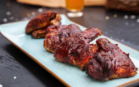 Saftige chicken wings in einer würzigen Marinade, serviert auf einem hellblauen Teller.