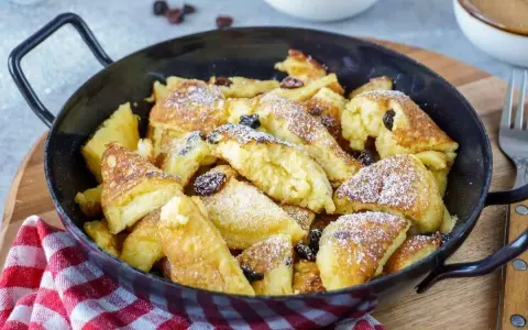 Kaiserschmarrn, fluffig und goldbraun, mit Rosinen und Puderzucker bestreut, zubereitet im Thermomix.