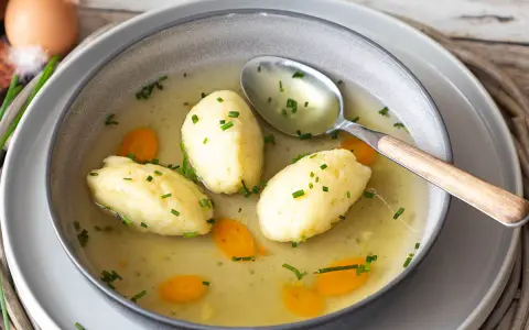 Schon die Vorstellung, dass Grießnockerl nicht weich werden, ist ein Graus! Hier schwimmen sie perfekt in klarer Brühe mit Karotten und Schnittlauch.