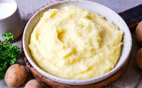 Cremiger Kartoffelbrei, perfekt für jedes Kartoffelbrei Rezept. Mit frischer Petersilie und Milch daneben.