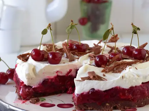 Ein saftiger Kirsch Sahne Kuchen mit frischen Kirschen und Schokostreuseln, bereit zum Genießen.