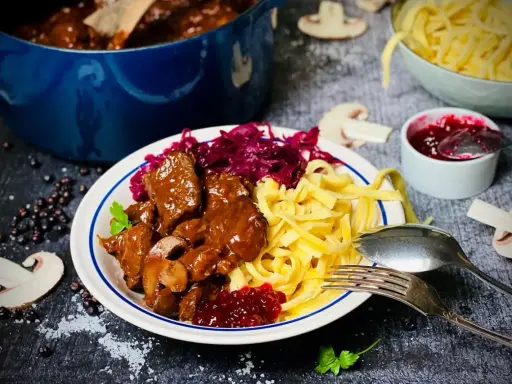 Herzhaftes Rehgulasch mit Spätzle, Rotkohl und Preiselbeeren. Ein köstliches Rehgulasch Rezept für Genießer.