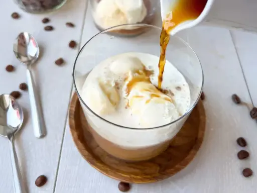 Ein heißer Espresso fließt über cremiges Vanilleeis. Ein perfekter Affogato Cafe, bereit zum Genießen.