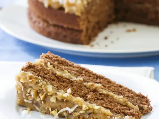 Ein Stück saftige Nusstorte mit cremiger Buttercreme und gehackten Nüssen, bereit zum Genießen.